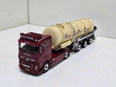 Scale model cement mixer truck: maroon Volvo cab with beige drum labeled 'Van Zuilen' on a white surface.