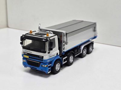 Scale model of a white and blue ballast truck with a long silver trailer on a white background, showing detailed cab and tires.