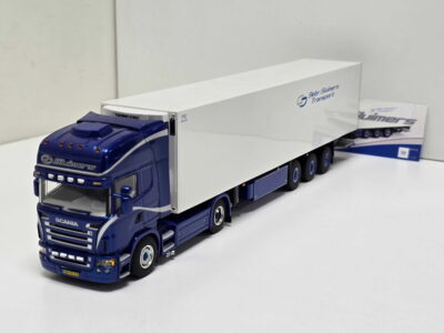 Blue Scania tractor unit attached to a white cargo trailer with Slumers Transport branding visible on the side.