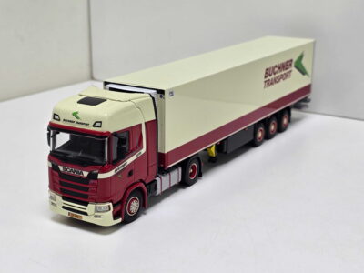 Scale model of a Scania tractor unit with a long beige trailer bearing Buchner Transport branding and a green arrow logo.