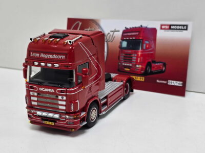 20260919_145505 - Degen Miniaturen Red Scania toy truck front close-up showing chrome grille, lights and 'Leon Hogendoorn' text on the cab, set on a white surface.