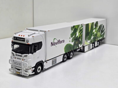 20260919_145906 - Degen Miniaturen Scale model white Scania truck with a long, leaf-patterned trailer featuring green foliage and the words 'Novi flora' on the side.
