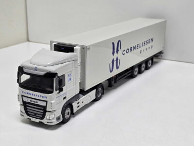 Scale model of a white DAF tractor unit with a long, branded trailer on a white surface, displaying the Cornelissen Group logo in blue.