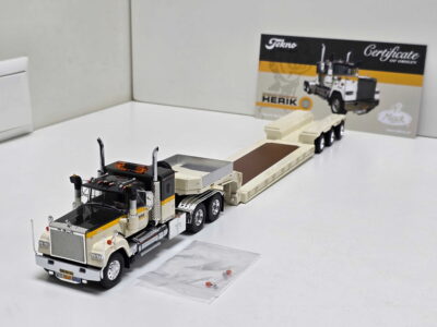 Scale model of a beige and black semi-truck with trailer on a white tabletop, packaging visible in the background.